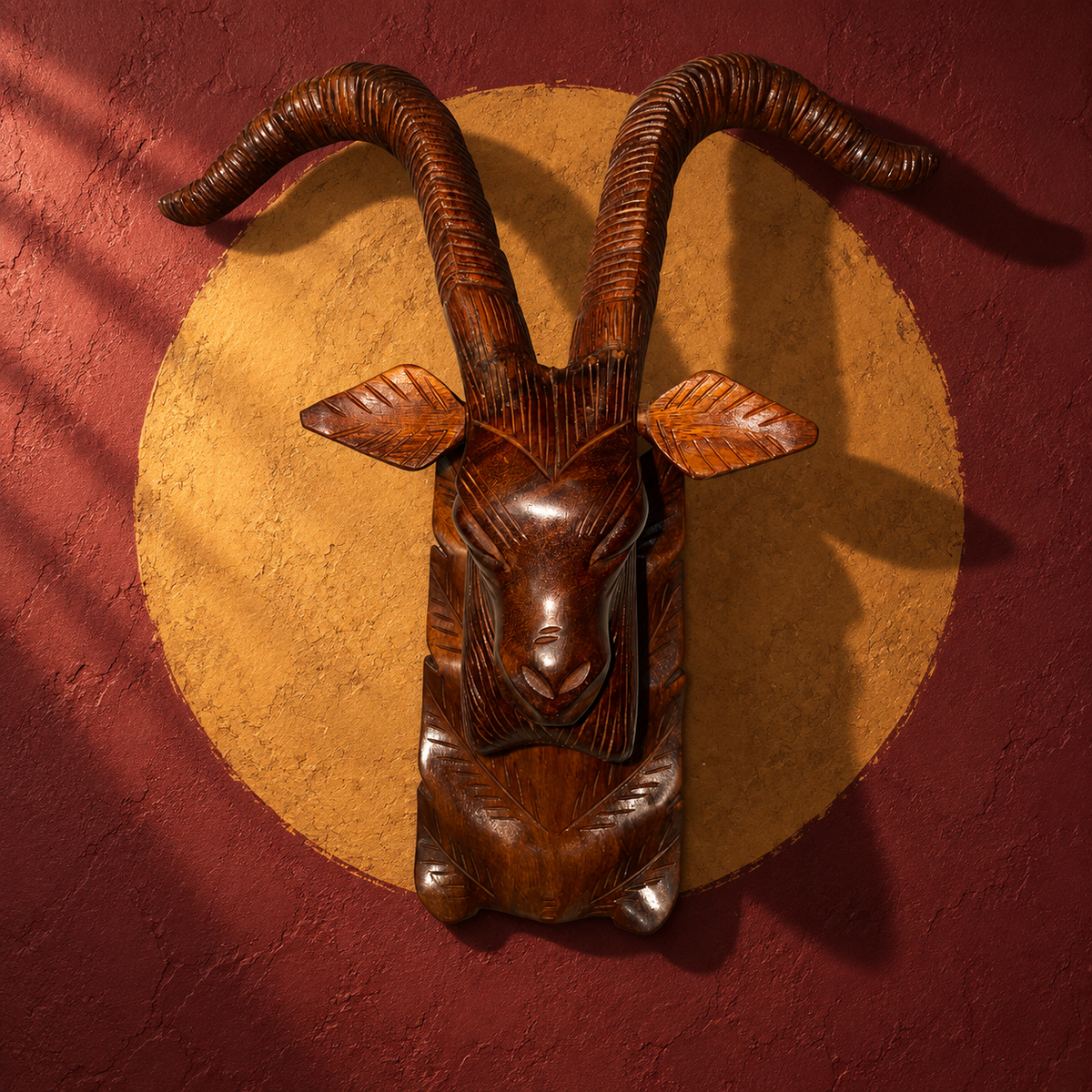 Wooden ibex head wall mount against a terracotta wall with a golden circle